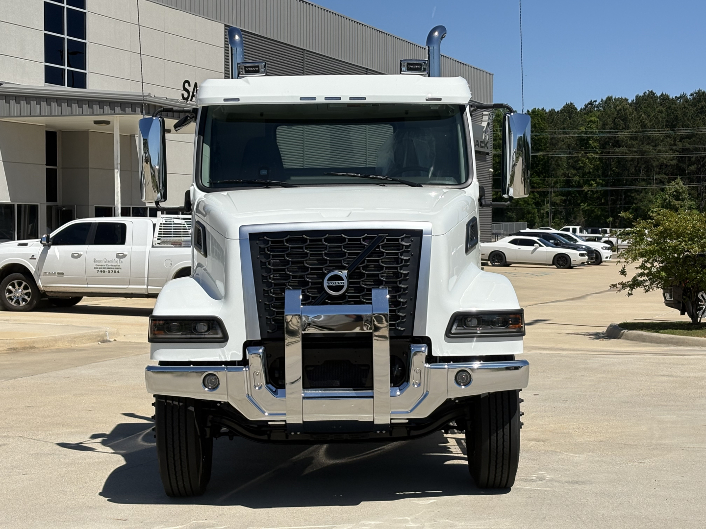 Volvo VHD64FT300 conventional daycab truck front view showing large grille, bumper guard, and side mirrors.