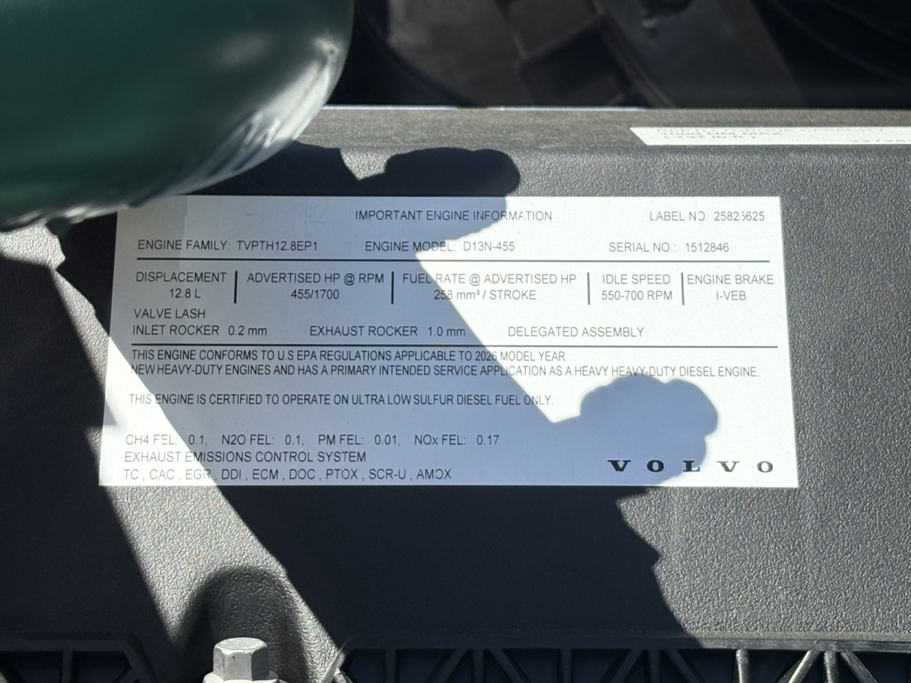 Engine information label on Volvo VHD64FT300 engine bay showing engine family graphic, serial number, and oil/engine specifications.