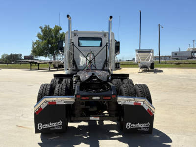 Rear view of a 2027 Volvo VHD64FT300 low-profile tractor chassis showing dual rear axles, mud flaps with Bruckner's Equipment logo, and rear bumper area.