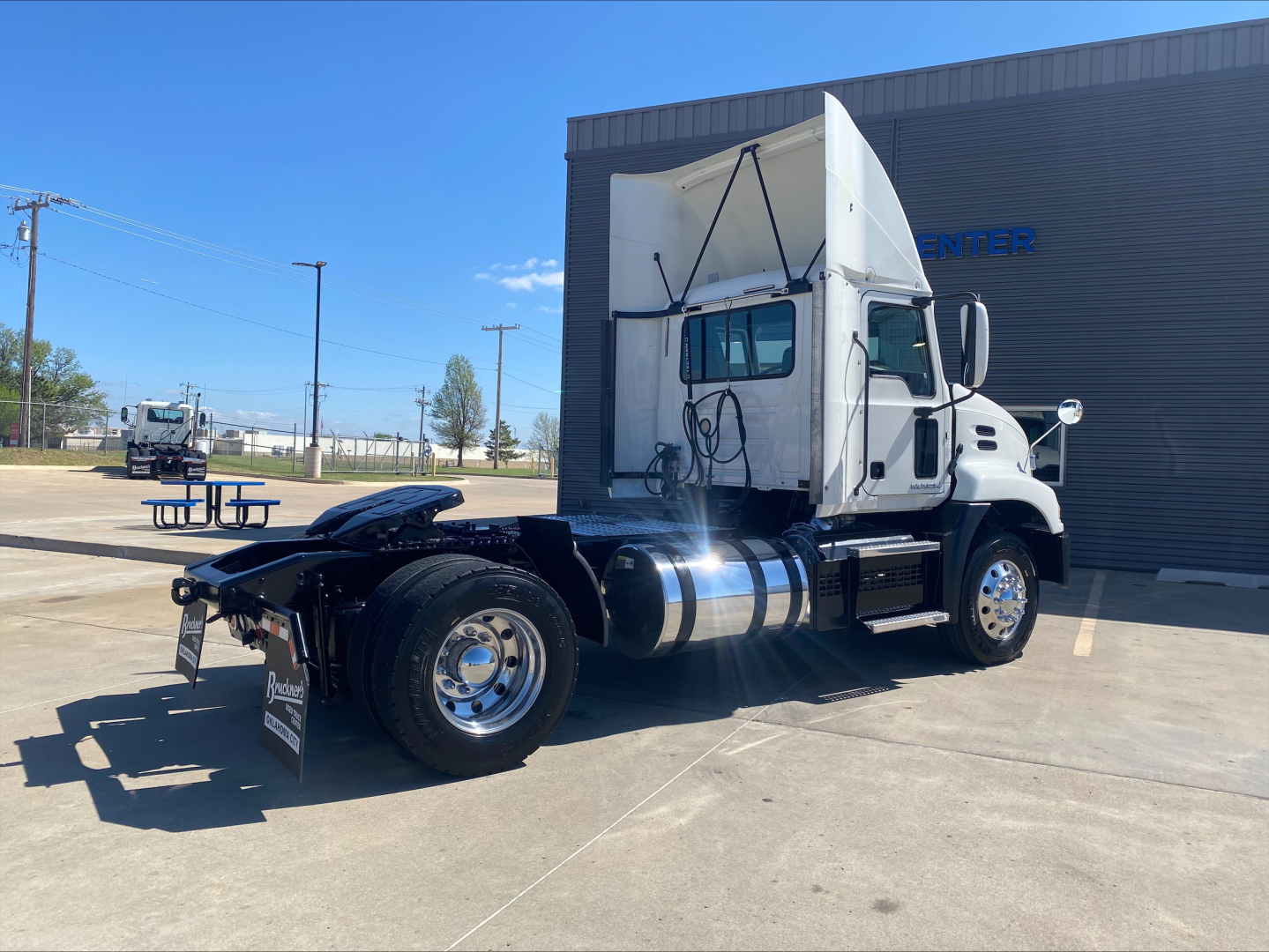 Truck: 2018 Mack CXU612 conventional daycab tractor, side view showing cab, fuel tanks, chrome exhaust, dual rear wheels, and fifth wheel absent; VIN 1M1AW06Y7JM011085 visible in listing.