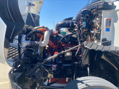 Truck engine bay of a 2018 Mack CXU612 with visible engine components and hoses
