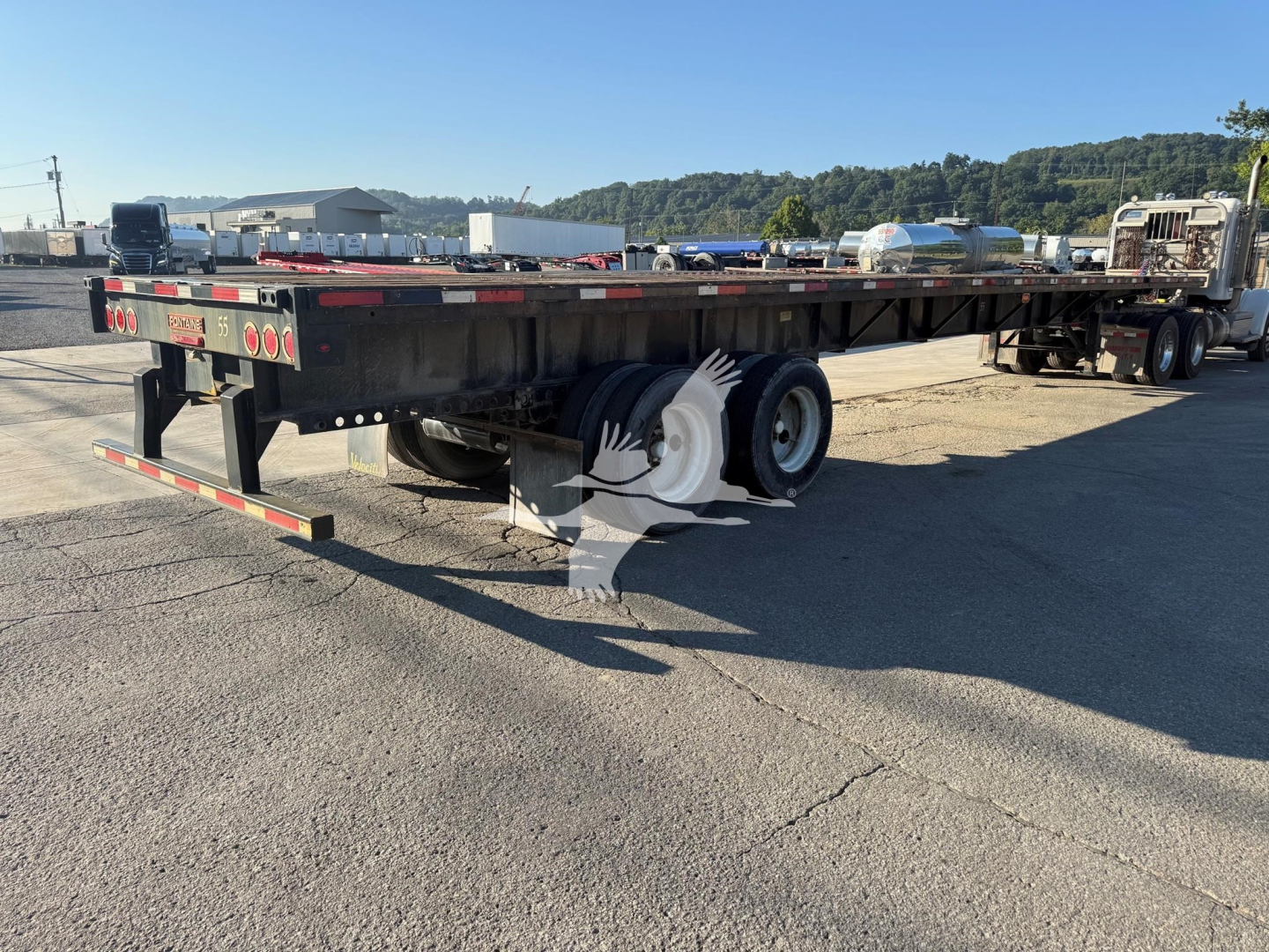 Flatbed trailer showing rear view with dual rear axles and spare tires, Fontaine XTP model features visible