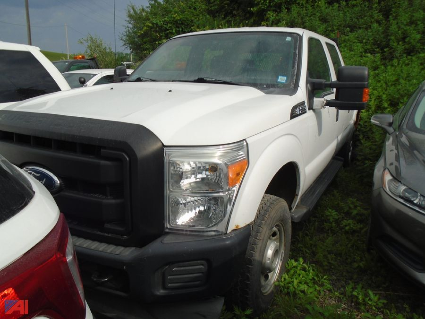Ford F-250 pickup truck in white, front-left view, two-tone black grille and bumper, utility mirrors, in a lot.