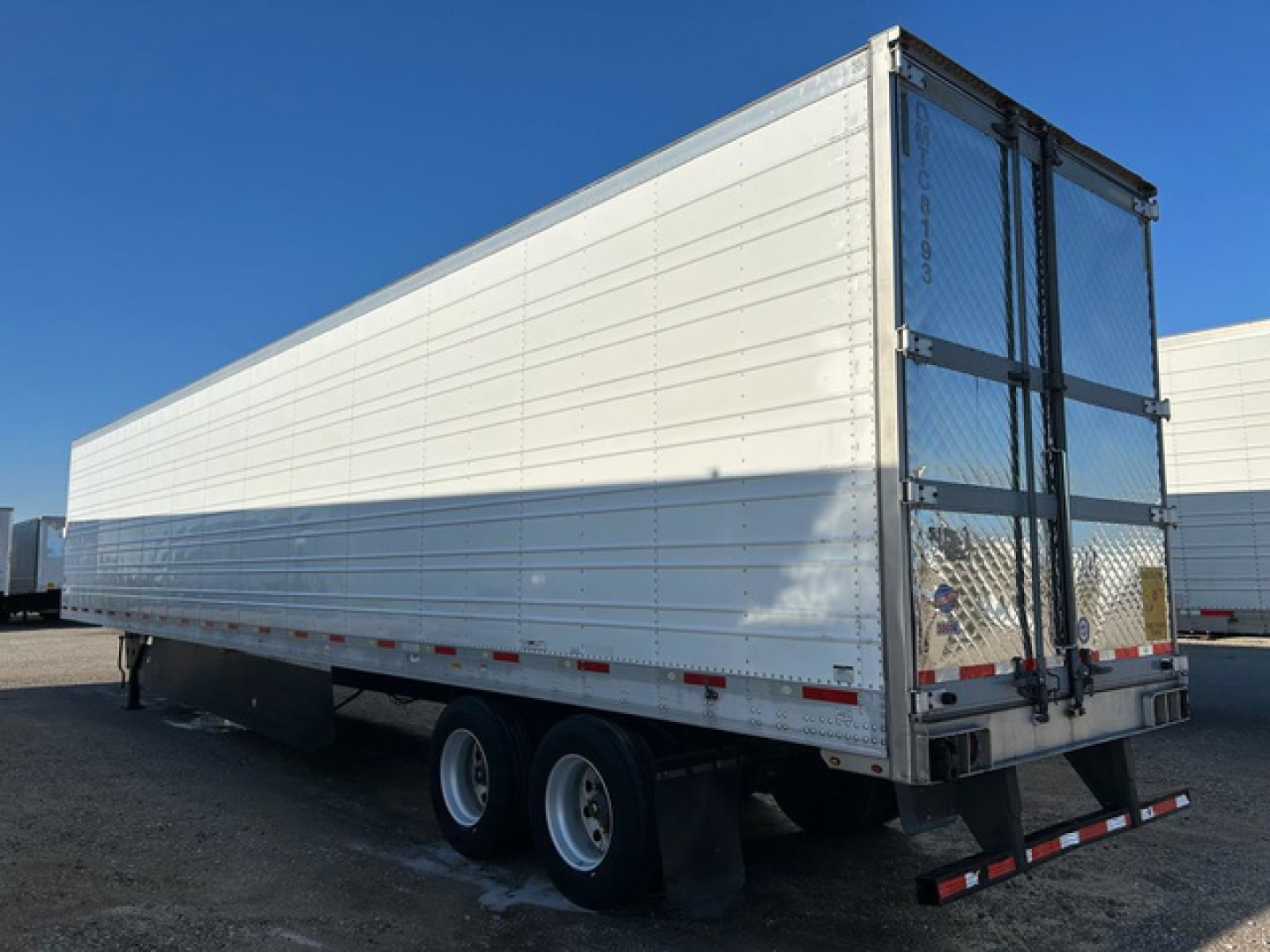 2016 Utility Reefer trailer side and rear view showing aluminum exterior, dual rear doors, and wheel axles. VIN 1UYVS2538GM454113