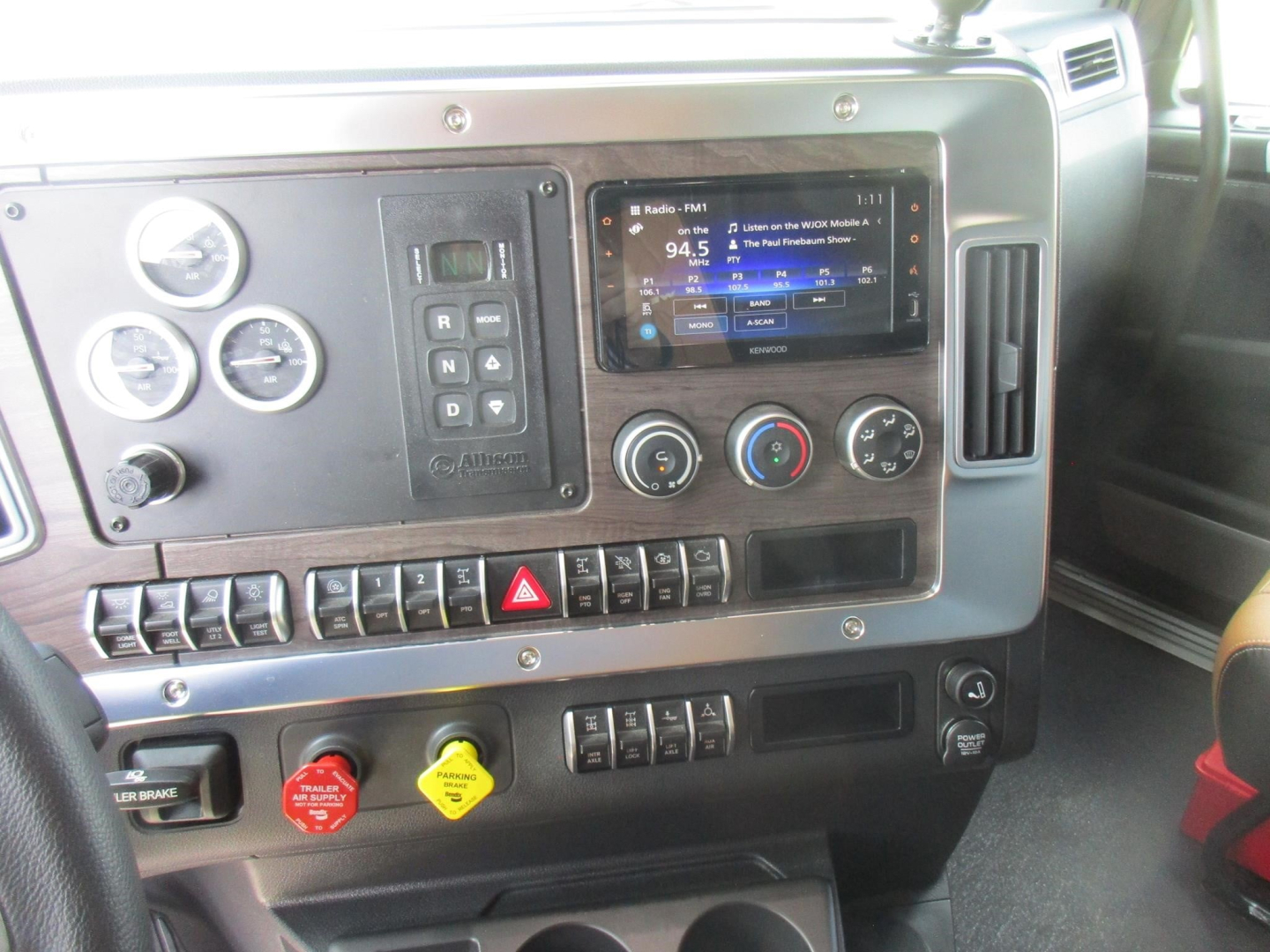 Dashboard view of a Western Star 49X truck interior with gauges, touchscreen radio, climate controls, and various switches.
