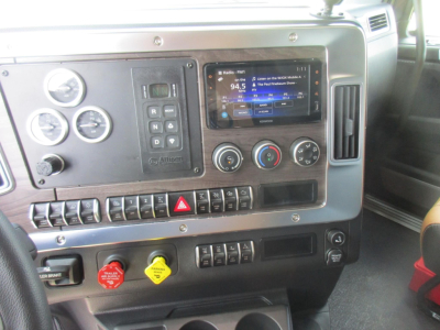 Dashboard view of a Western Star 49X truck interior with gauges, touchscreen radio, climate controls, and various switches.