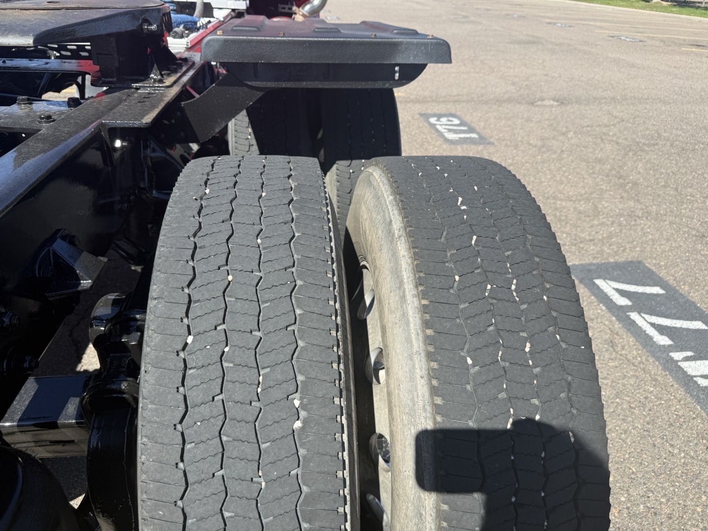 Kenworth T880 tractor rear dual wheels with tread details and chassis frame near wheel wells.