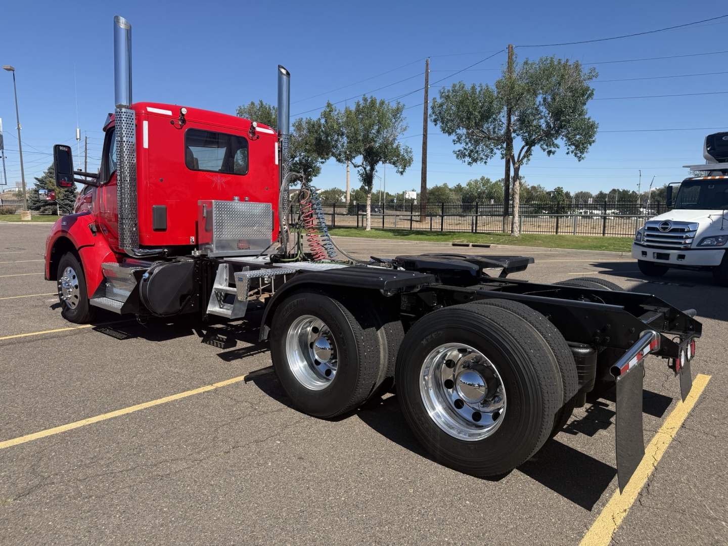 Kenworth T880 tractor chassis with red cab and dual rear axles, side exhaust stacks, chrome fuel tanks, and fifth wheel area visible.