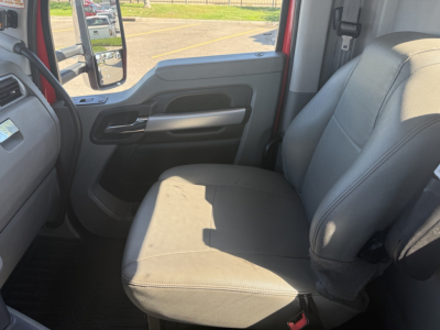 Kenworth T880 truck interior passenger seat and door panel showing gray fabric seat and armrest, window controls on door, light gray interior