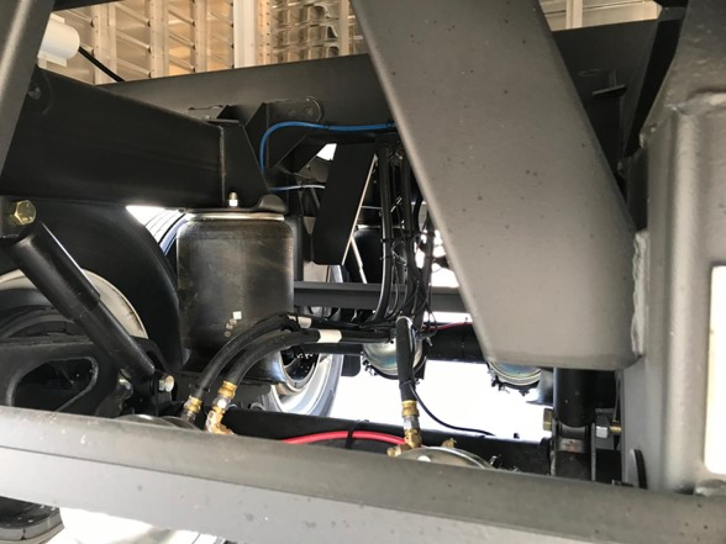 Trailer component view showing hydraulic lines and frame of a new Timpte Super Hopper trailer hopper system.