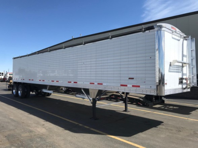 Trailer side view showing a new 2026 Timpte Super Hopper aluminum hopper with dual rear axles and landing gear, stock NE6452.