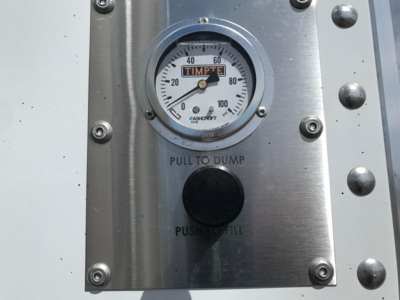 Timpte gauge panel showing 0-100 scale with 'TIM PTE' label and pull-to-dump, push-to-fill buttons and metal riveted plate