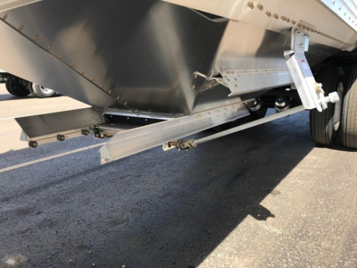 Hopper trailer undercarriage and suspension showing steel frame, support beams, and wheel hub; no legible label text visible in this view.