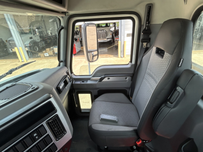 Cab interior of 2027 Mack GR64F truck showing front passenger seat and door window with mirror, dashboard controls.