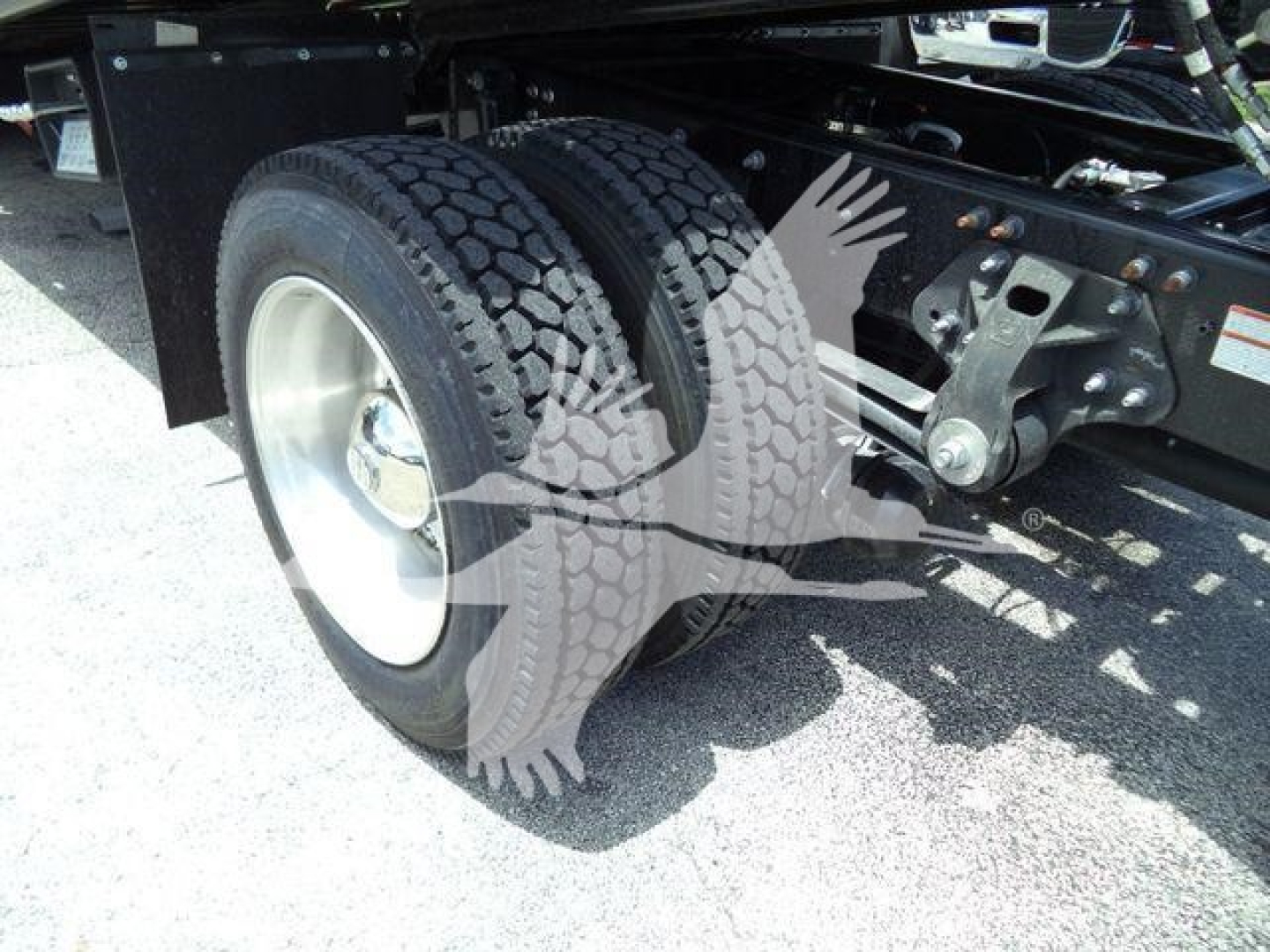Dual rear tires on a Hino truck chassis showing dual wheel setup and suspension components.