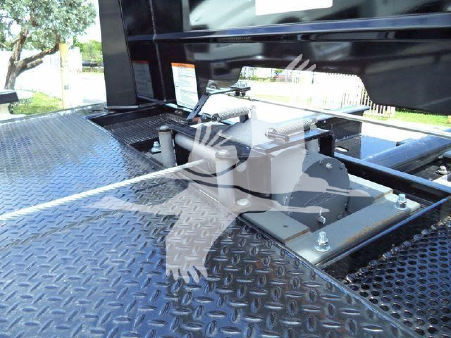 Hino L6 rollback truck component mounting on diamond plate platform showing winch assembly and mounting bolts.