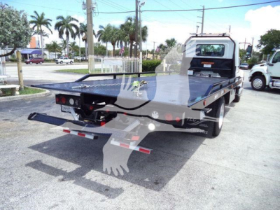 Truck bed on a 2027 Hino L6 rollback tow truck, flatbed rear with undercarriage hitch and rear lights visible.