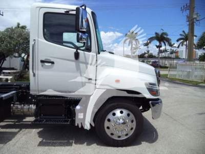 Truck cab side view showing 2027 Hino L6 with white exterior and single rear wheel visible, daytime outdoor setting.