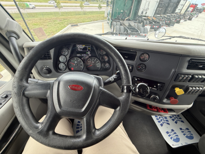 Peterbilt 579 interior dashboard and steering wheel view from driver seat showing instrument cluster and center console.