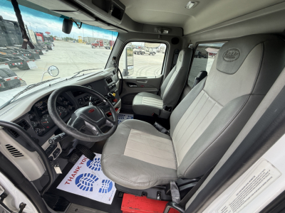 Peterbilt 579 cab interior showing steering wheel, dashboard, and two-tone fabric seats in a Daycab truck.