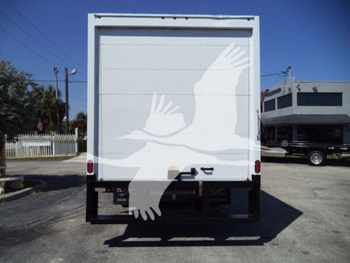 Rear view of a white Ford E-450 box truck with high cube cargo area. No visible text on back doors; trailer hitch and rear bumper visible.