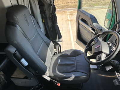 Kenworth T680 truck cab interior: driver's seat and steering wheel visible, door panel with controls, dashboard area, general cabin view.