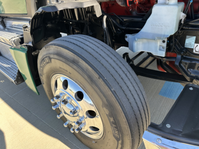 Kenworth T680 front wheel and suspension area showing tire, wheel, and front bumper components
