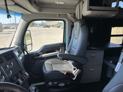 Kenworth T680 interior cabin with driver seat, dashboard, and sleeper area. Visible text includes: VIN plate not legible from image, dashboard controls, overhead storage, and seating.