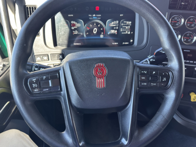 Kenworth T680 steering wheel and instrument cluster, digital gauge display visible in dashboard.