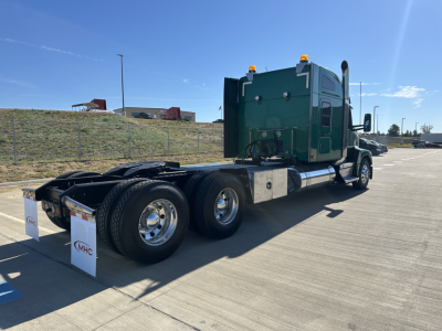 Kenworth T680 tractor with green cab, dual rear axles, lone sleeper cab, in-service trailer hitch area visible.