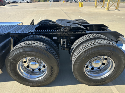 Kenworth T680 truck rear dual wheels and fifth wheel hitch area showing heavy-duty tires and chrome wheel rims, part of a sleeper cab tractor.