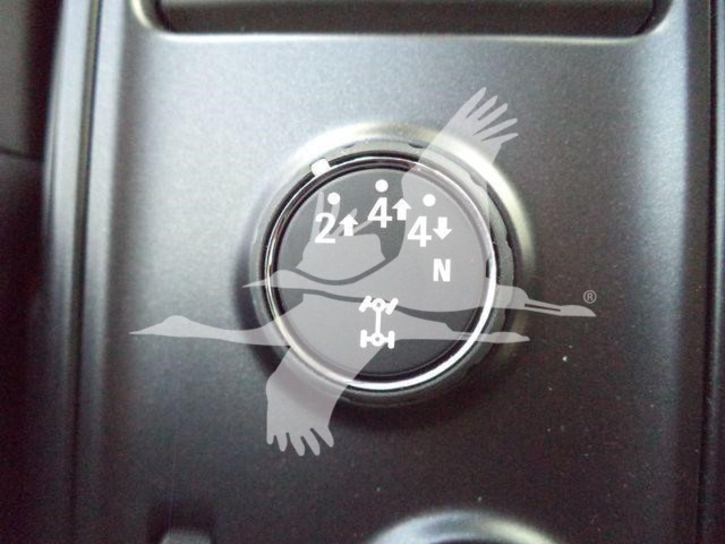 Gauge/indicator dial showing 1x4 gear positions in a vehicle dashboard area with surrounding black panel.