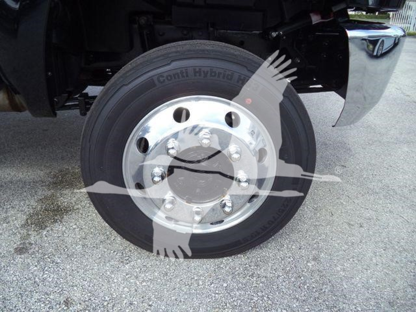 Truck wheel with Conti Hybrid tire and polished steel hub, underbody components visible.