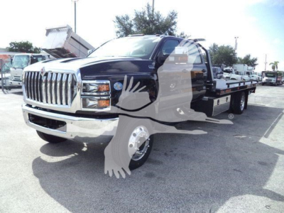 2023 International CV truck in a dealership lot with flatbed trailer and stock number J19810FM.