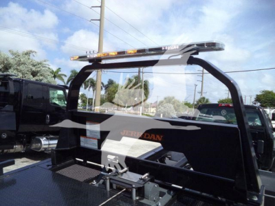 No text clearly legible besides a JERADAN/jerdan style bar on a rollback truck bed with a light bar on top.