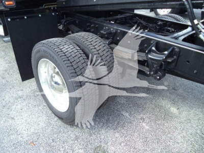 Truck chassis with dual rear wheels and undercarriage components visible.