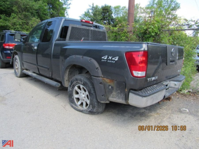 Nissan Titan pickup truck with 4x4 Off Road badge and extended cab, rear view showing bed and rear bumper.