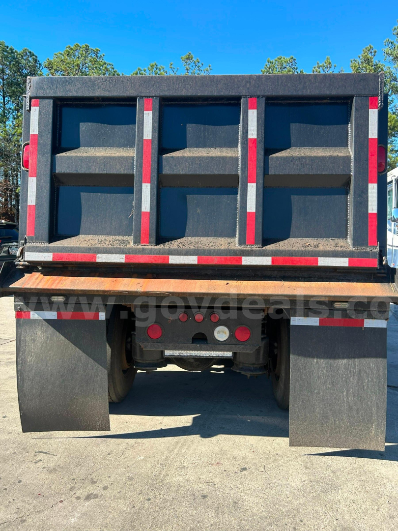 Dump truck bed of a Freightliner Cascadia 125 rear view showing dump body with three side panels and rear underride protection. No visible text legible on the body.