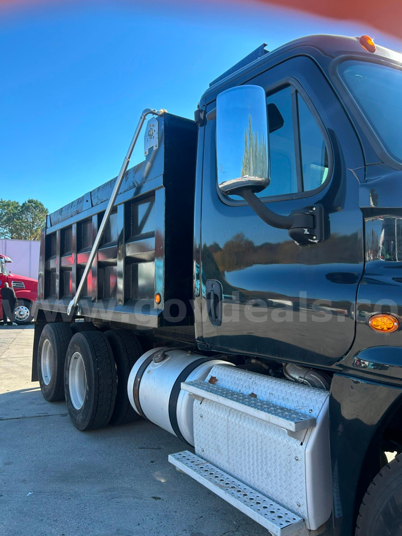 Truck cab and dump bed side view showing chrome fuel tank and steps, 2018 Freightliner Cascadia 125 dump truck.