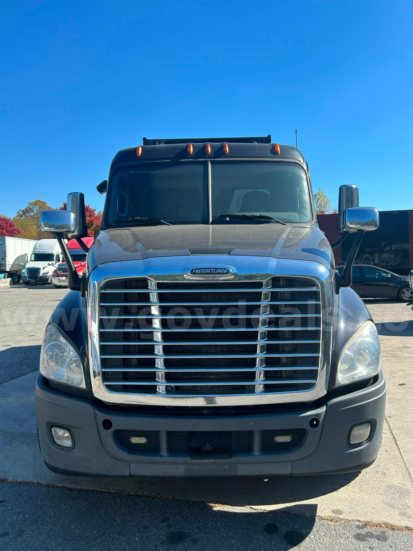 Front view of a Freightliner Cascadia 125 dump truck showing chrome grille, headlights, and hood with windshield and side mirrors.