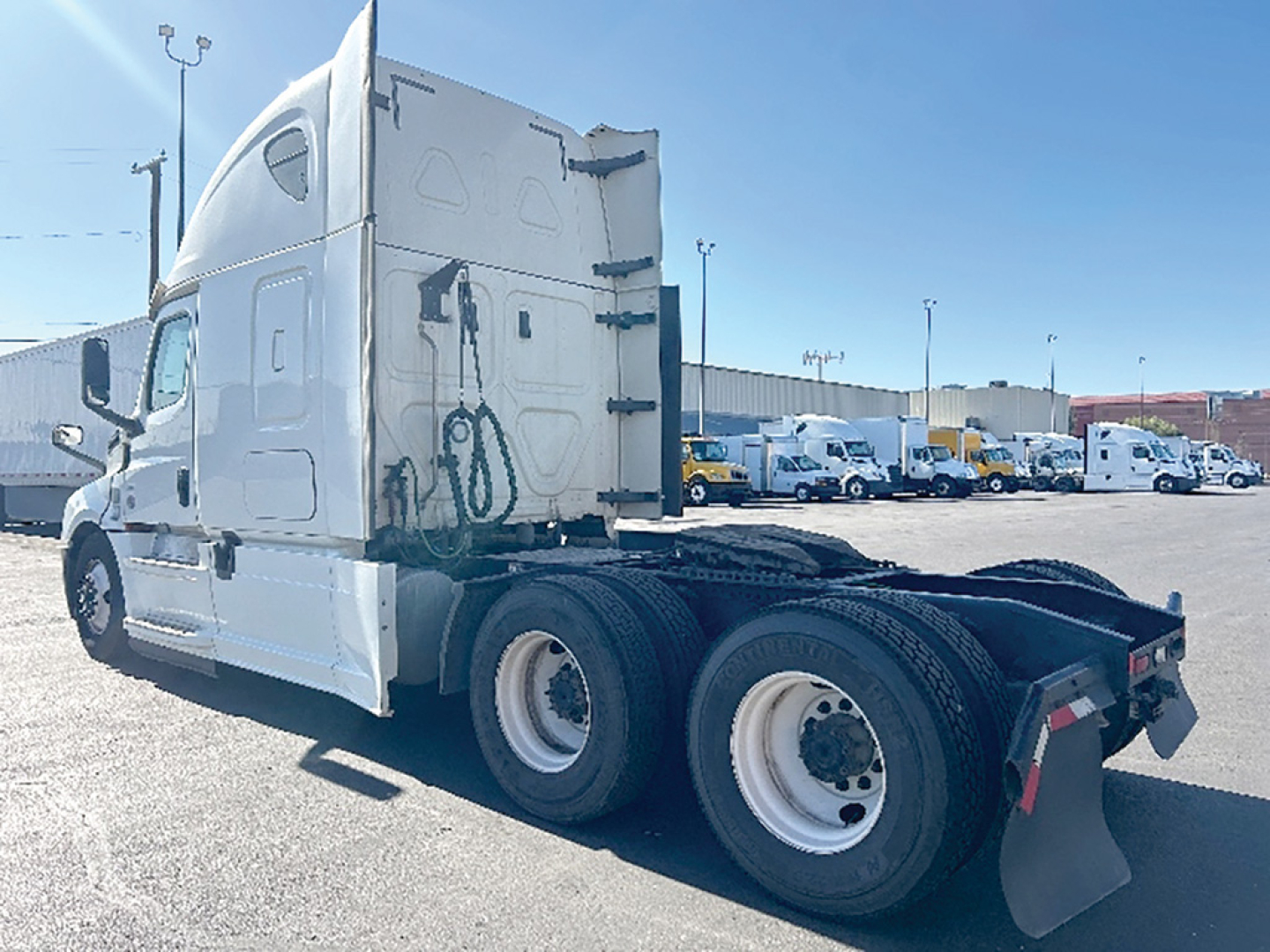 Freightliner Cascadia126 tractor rear/side view showing truck chassis and dual rear axles in a dealership lot.