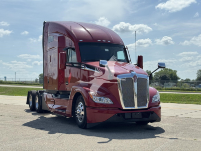 Kenworth T680 truck in maroon showing front grille and headlights with sleeper cab and dual rear wheels.