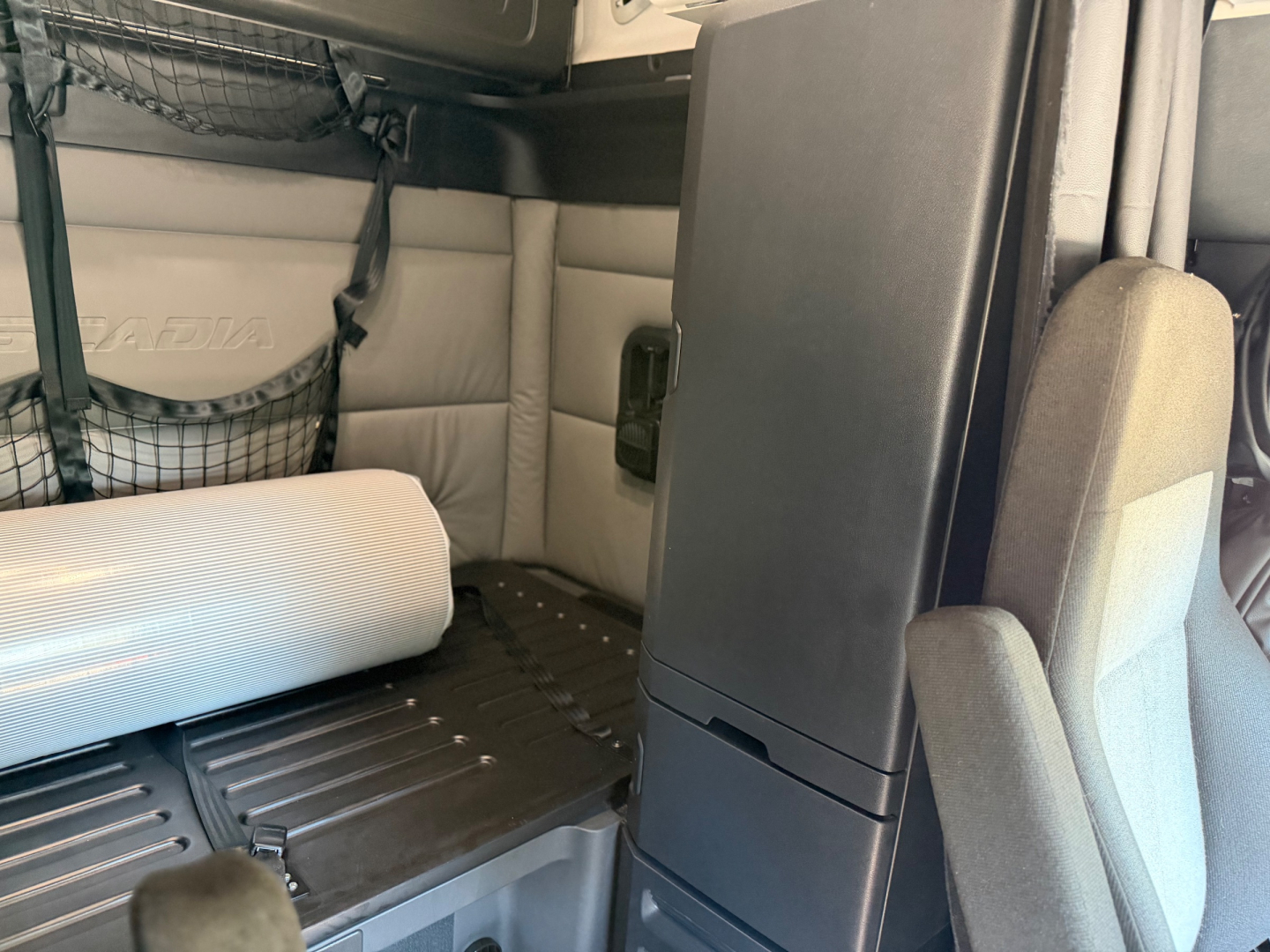 Truck cab interior of a 2022 Freightliner PT126064ST showing sleeper area and seating with storage compartments.