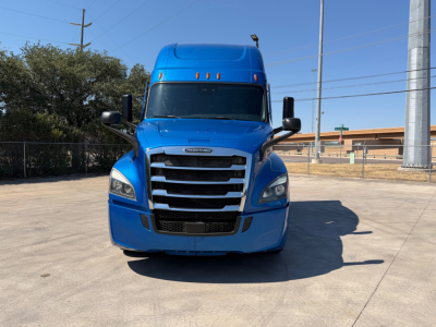 Front view of a blue Freightliner PT126064ST truck showing large grille, bumper, and side mirrors.