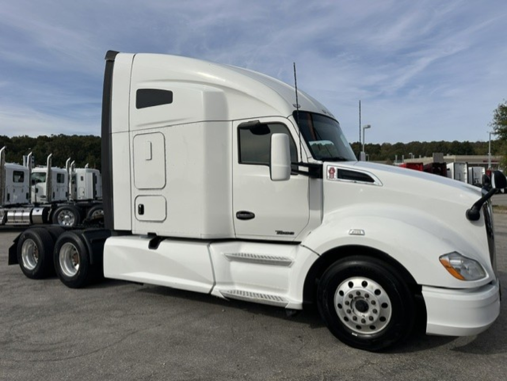 Kenworth T680 tractor-trailer in white, side profile view showing sleeper cab and front wheel, with VIN 1XKYD49X8LJ227034 and stock on truck lot.