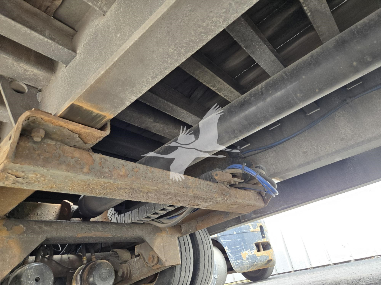 Landoll trailer underside showing frame rails and hydraulic lines with rusted steel components.