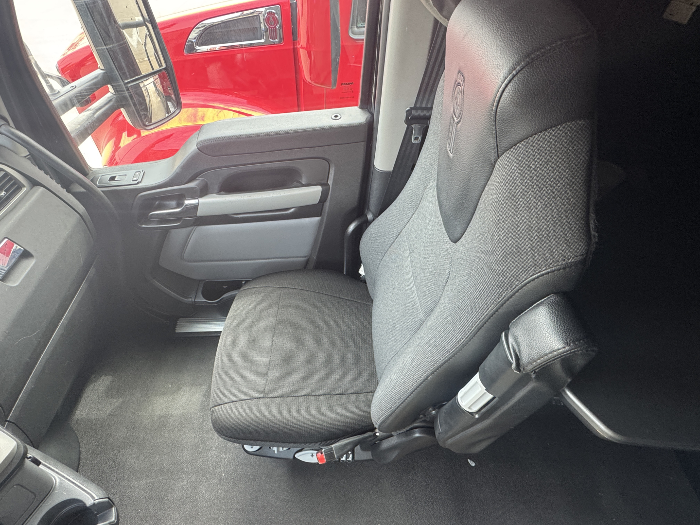 Kenworth T680 truck cab interior showing driver's seat and door panel.