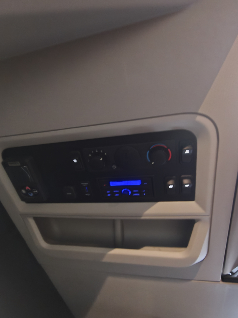 Cabin dashboard panel in Kenworth T680 showing radio and climate controls