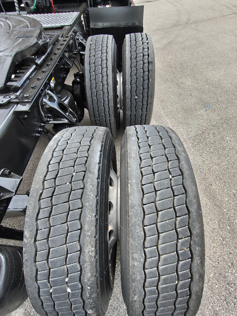 Kenworth T680 rear dual-axle wheels and chassis showing tire tread and suspension components.