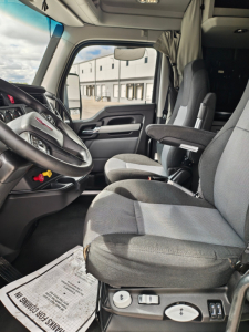 Kenworth T680 truck cabin interior showing driver seat and control panel.